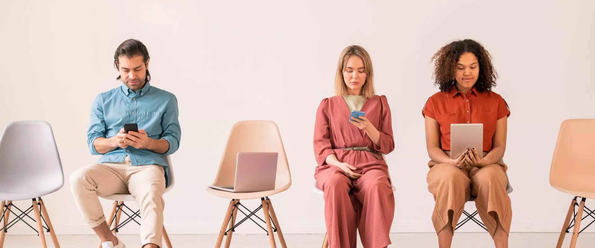 Eine Gruppe von Menschen, die auf Stühlen sitzen und mit ihren Telefonen auf Instagram surfen und gesponserte Werbung ansehen.