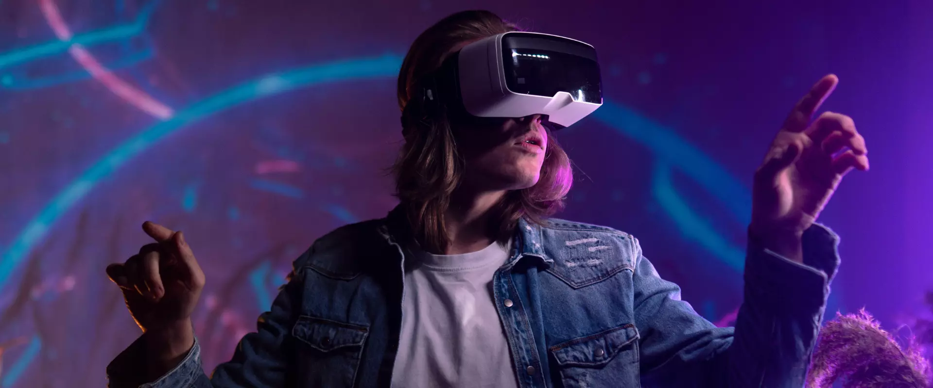 Eine Frau in einer Jeansjacke, die ein VR-Headset trägt.