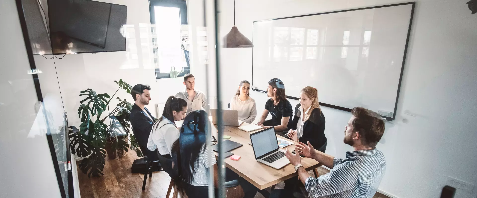 Eine Gruppe von Performance Marketing Fachleuten trifft sich an einem Konferenztisch in einem modernen Büro.