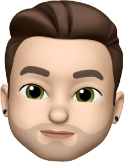 Ein Memoji-Charakter mit gestyltem braunem Haar, grünen Augen und hellem Bart, der schwarze Ohrstecker trägt.