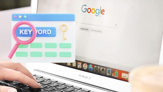 Eine Person tippt auf einem MacBook Air, während eine Google-Suchseite geöffnet ist, und führt eine Schlüsselwortanalyse durch. Eine bunte Grafik eines Schlüsselwortsuchsymbols ist über das Bild gelegt, während im Vordergrund eine dampfende Tasse Kaffee einladend steht.